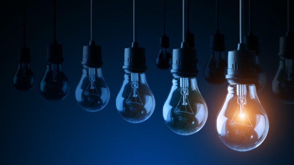 Many lightbulbs in rows, the front one lit up