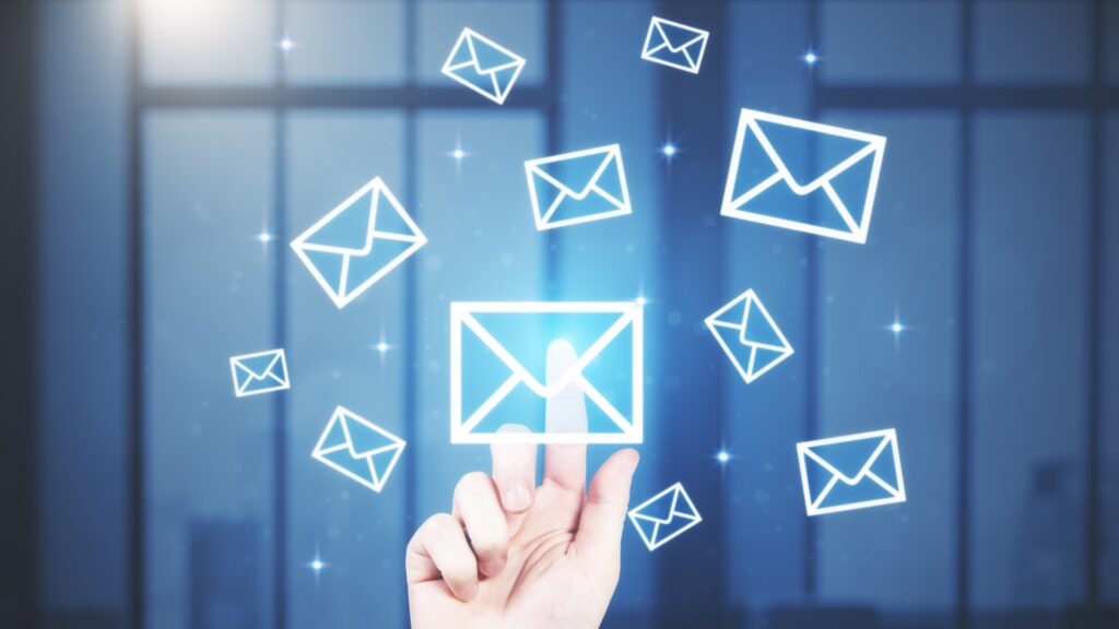 A hand selecting an email icon from floating icons, symbolising email marketing.