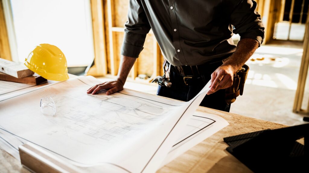 A man holding a blueprint in a construction site