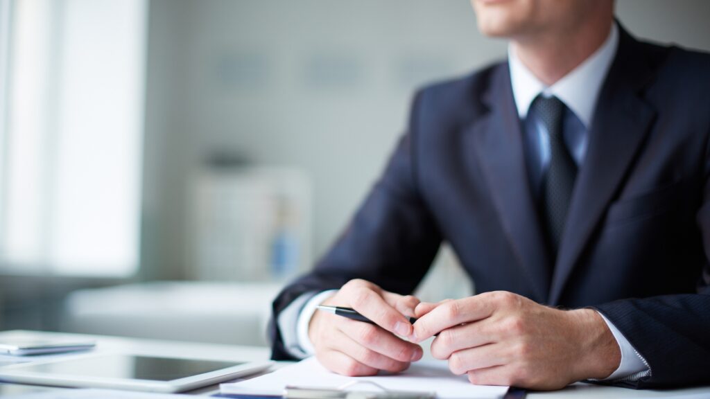 A close up of a man's hands holding a pen