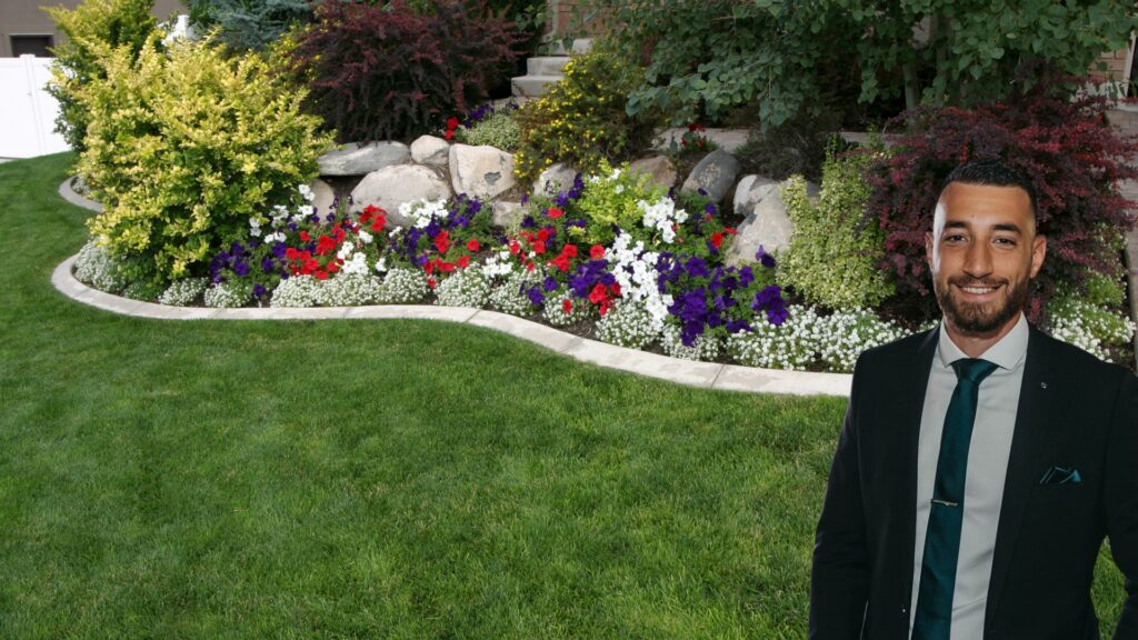 man in a suit standing confidently in front of a beautifully landscaped garden