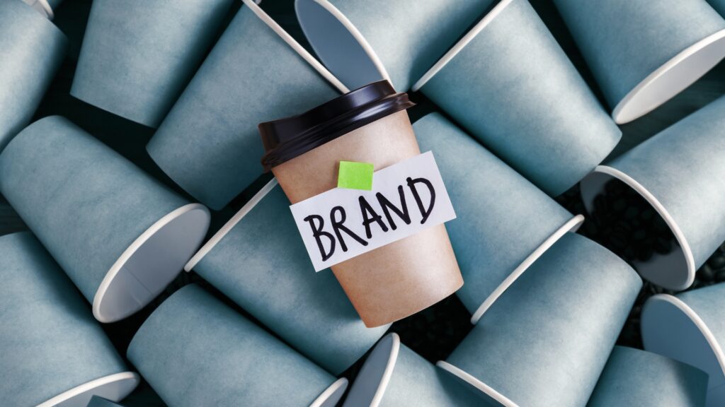 Coffee cup with 'Brand' label surrounded by blue disposable cups