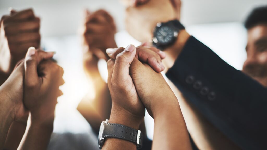 A group of people holding each others hands in the air