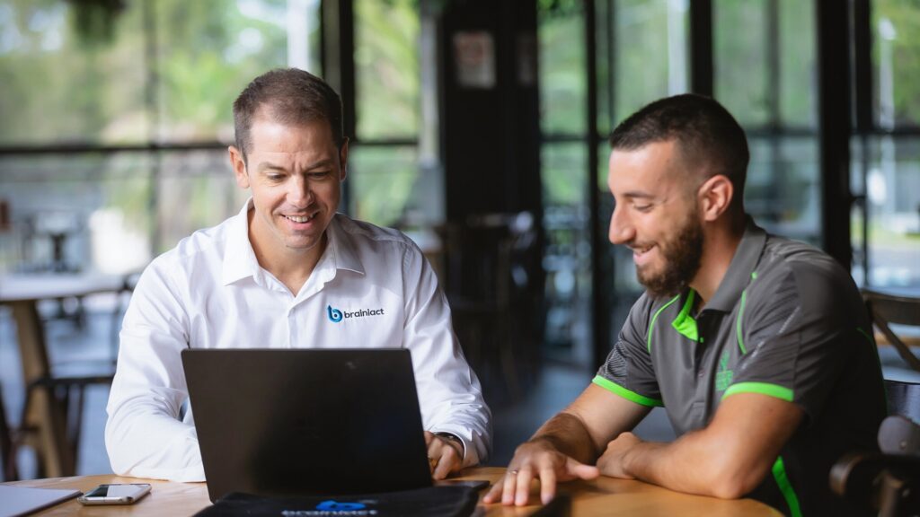 Business coaching session between two men with a laptop in between them