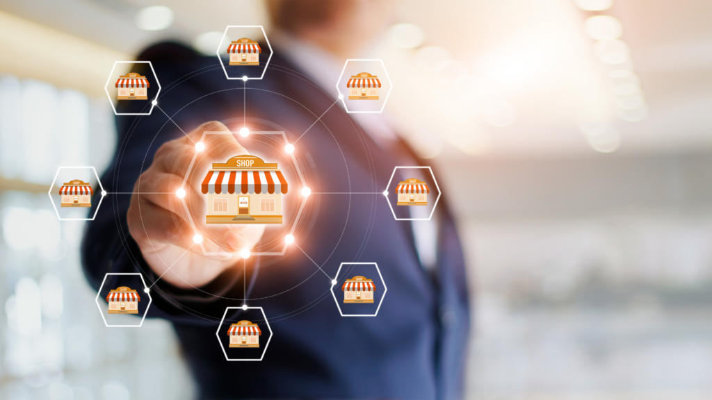 Businessperson interacting with a digital interface featuring icons of storefronts, representing franchise opportunities and expansion