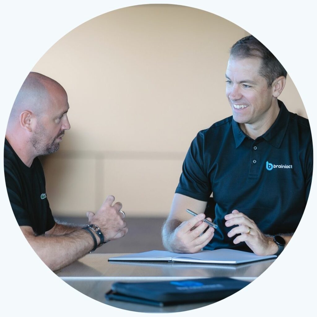 A business coach smiles, talking to his client