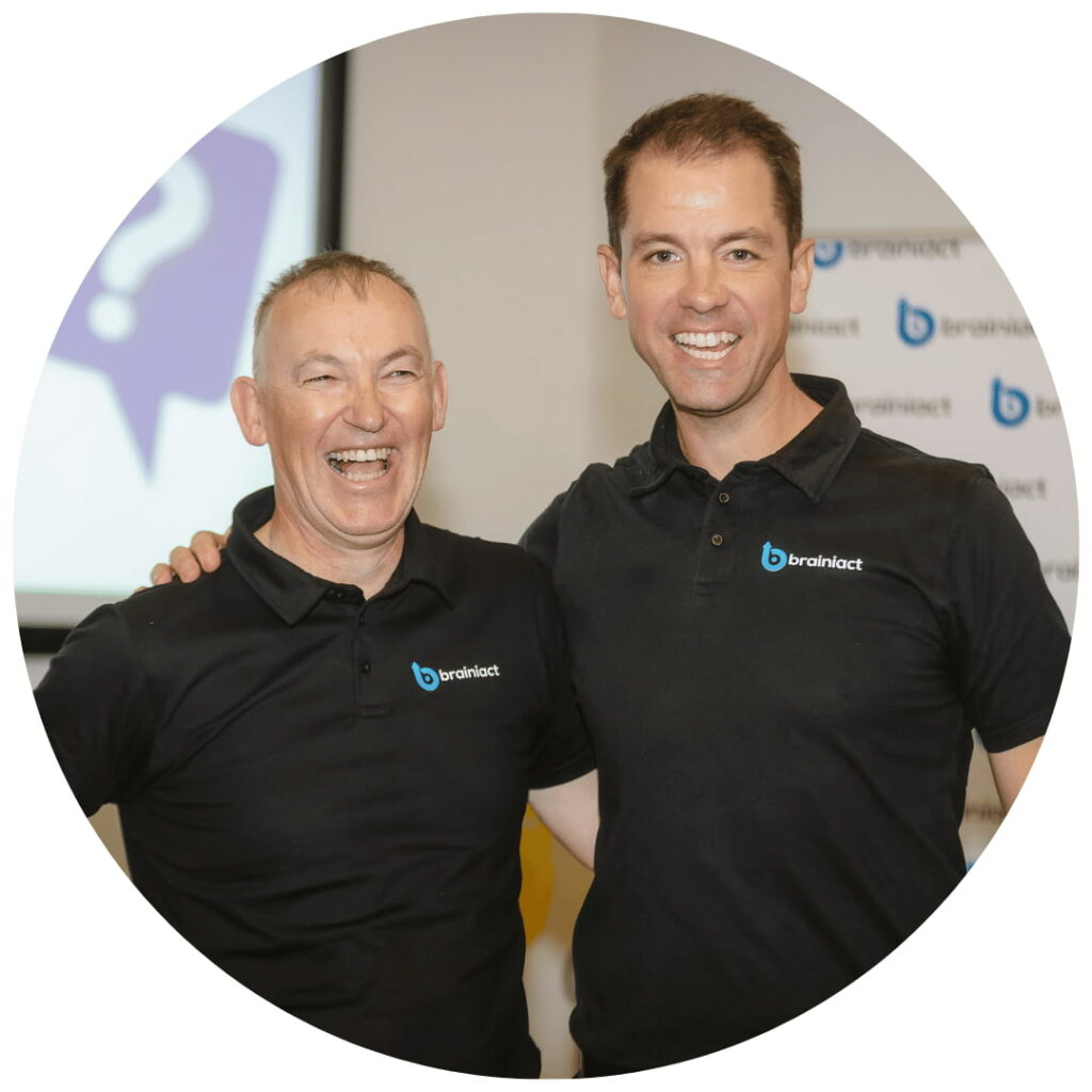 two coaches stand together, smiling